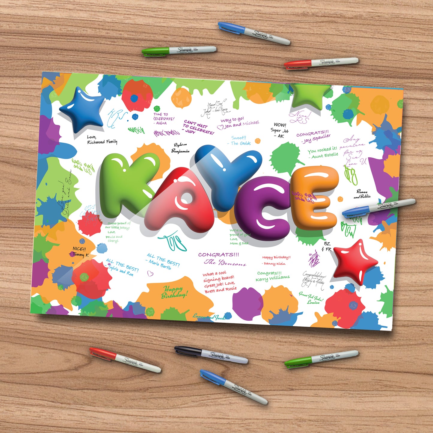 This image features a colorful, personalized acrylic birthday signing board with the name "KAYCE" in bold, balloon-style letters. Surrounded by vibrant paint splatters and 3D star accents, the board is filled with handwritten messages in various ink colors. It rests on a wood surface with Sharpie markers scattered around, inviting guests to sign. A playful, eye-catching keepsake perfect for birthday celebrations.