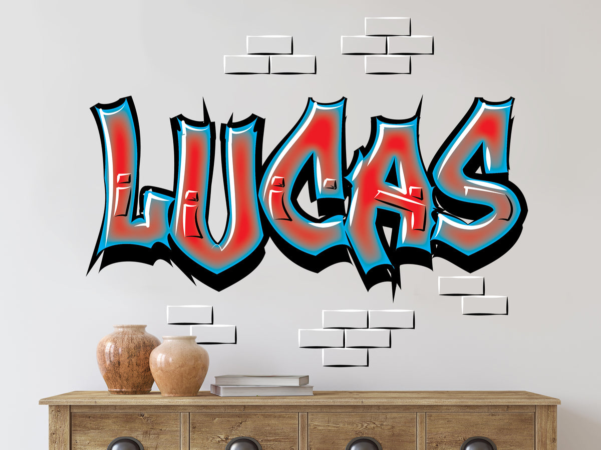A bold, graffiti-style wall decal featuring the name "Lucas" in vibrant red and blue with a black outline, giving it a street-art vibe. The design includes faux 3D brick accents, creating an urban aesthetic. Placed above a rustic wooden dresser with decorative vases and books, this decal adds a personalized, edgy touch to any modern or teen room. #GraffitiDecor #CustomWallArt #StreetArtVibes